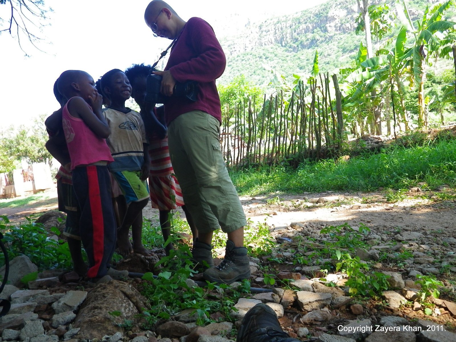 Zayera Khan shows her camera to local children on a village path in South Africa.