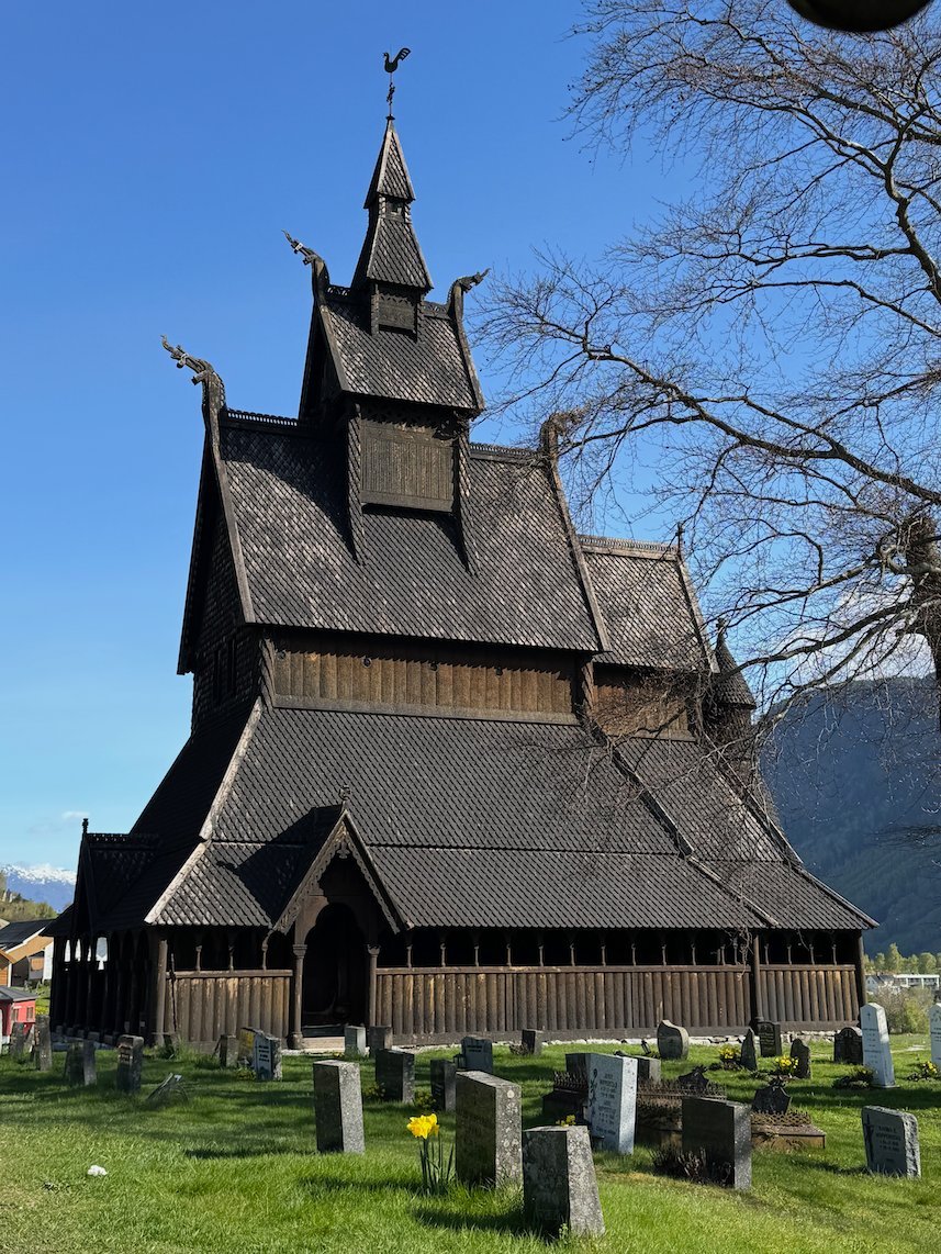 Hopperstad stave church with its graveyard and dragon heads on the roof