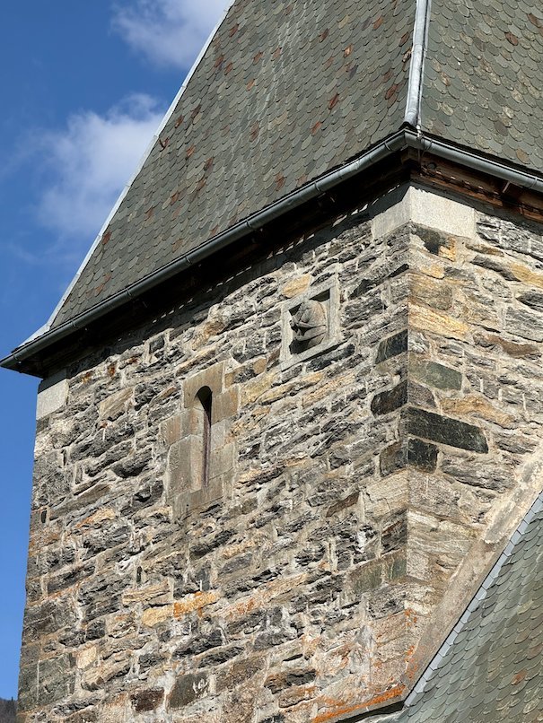 Stone wall and slate roof of the medieval Hove church, seen from below