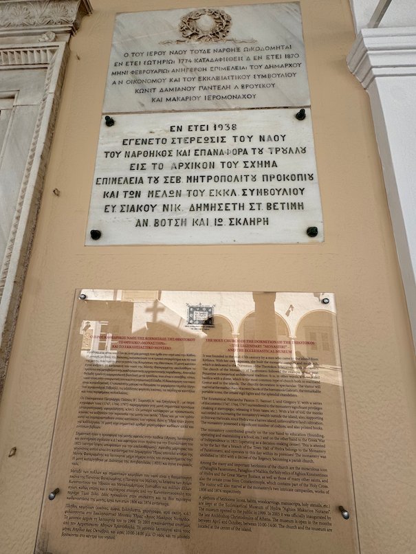Marble plaque with a Greek inscription and an information panel at the cathedral in Hydra