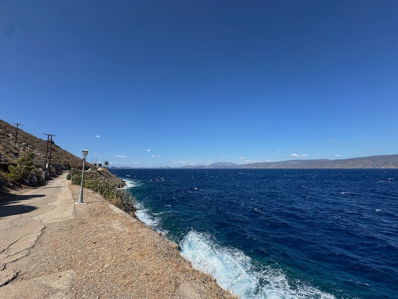 Coastal walkway along the sea with white waves in Hydra