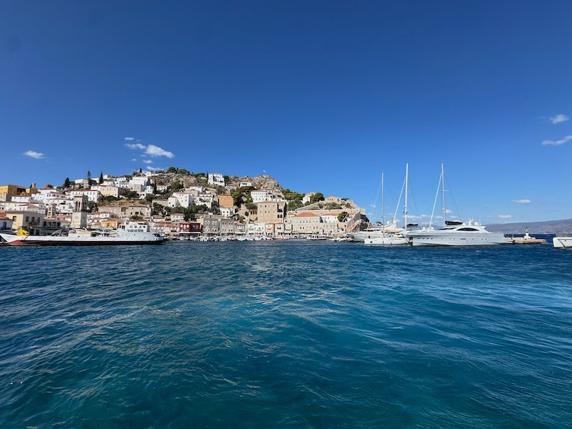 Hydra harbor and town with sailing boats, seen from the sea