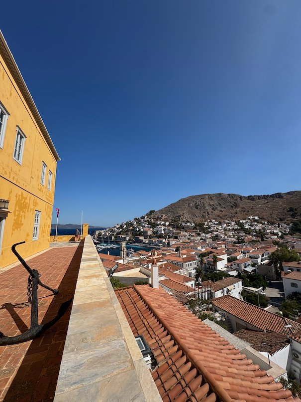 Terrace of an ochre mansion with a view over the roofs of Hydra