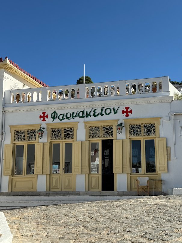 Old yellow pharmacy with the Greek word Farmakeion on the facade in Hydra