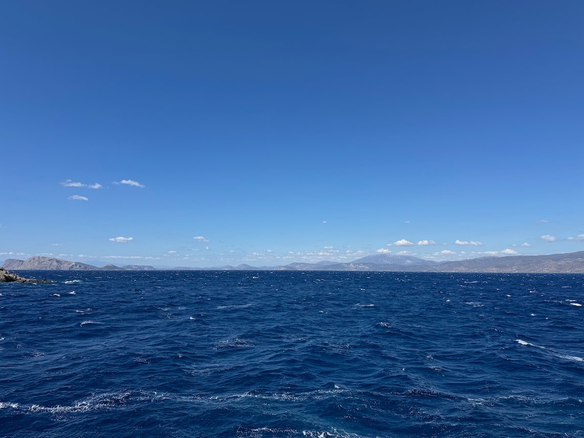 Open blue sea with small islands far away, seen from Hydra