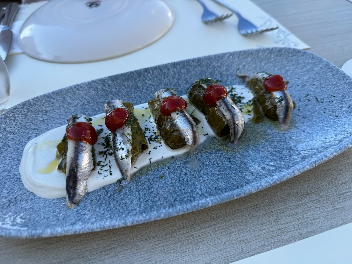 Marinated anchovies with red peppers on a grey plate in Hydra