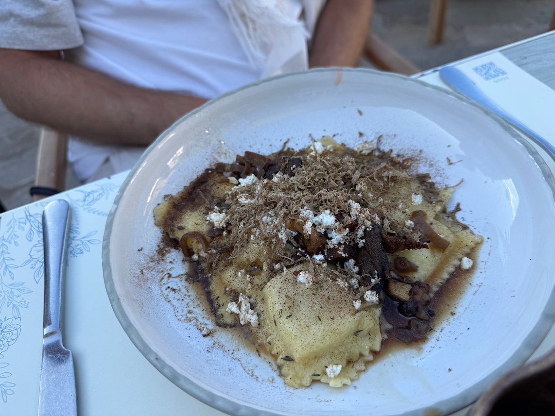 Plate of pasta with grated cheese and sauce at a restaurant in Hydra