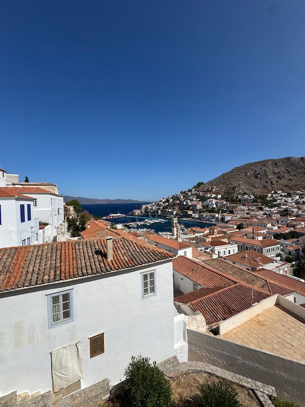 Red tile roofs and white houses with the harbor of Hydra below