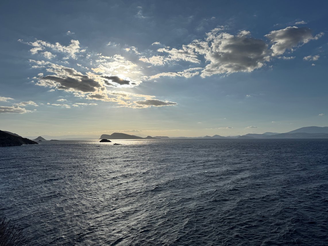 Clouds and sun over the sea and small islands near Hydra
