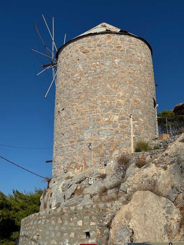 Old round stone windmill on a rock in Hydra