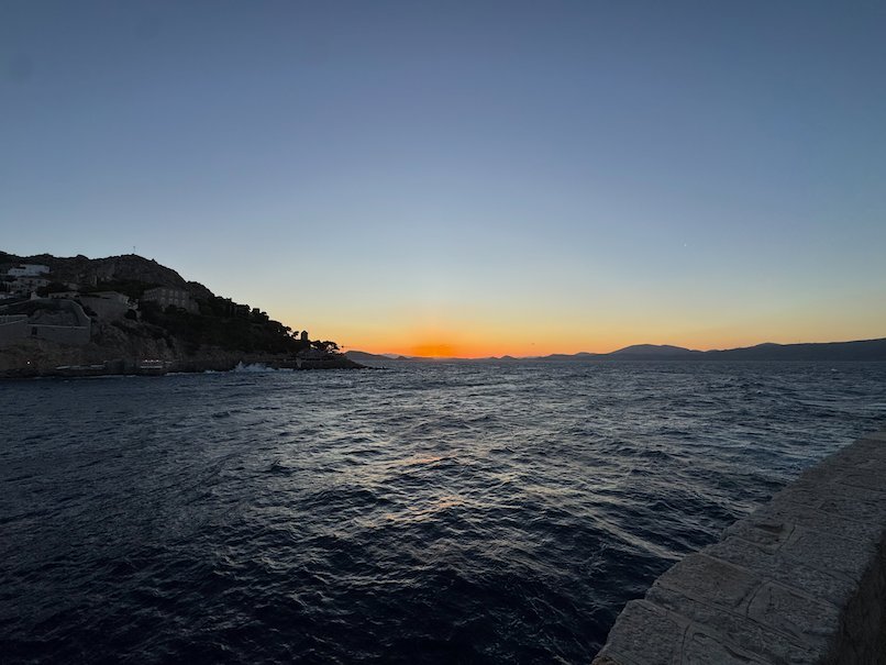Orange sunset over the coast and the sea at Hydra