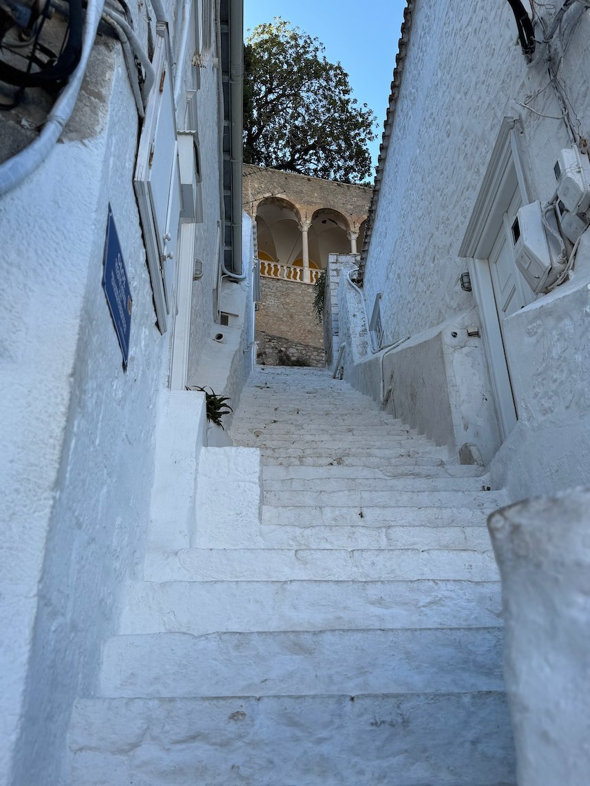 White stairs in a narrow lane between whitewashed walls in Hydra