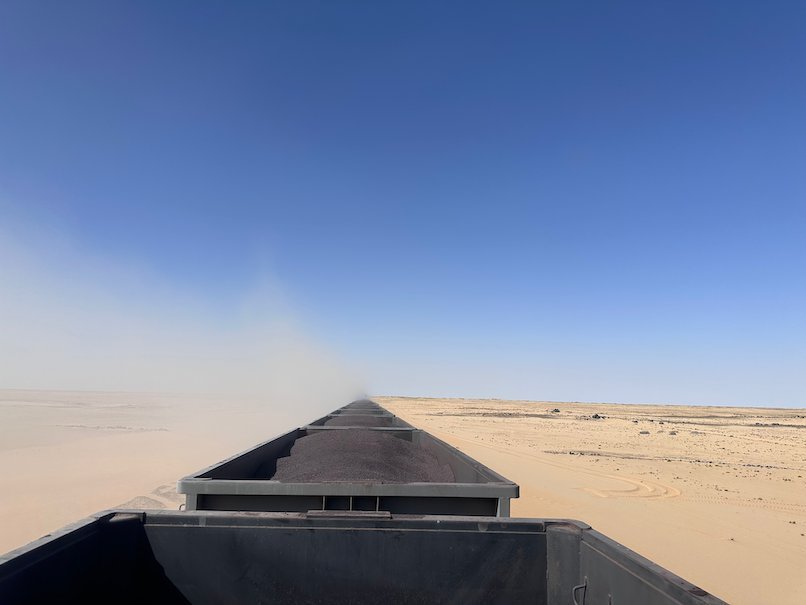 Dust rises from the ore wagons as the train crosses the desert.