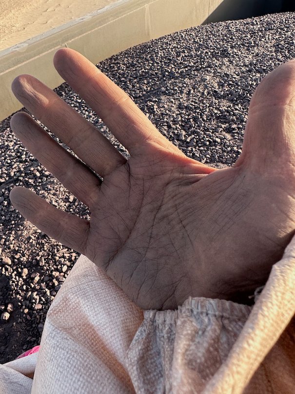 A hand covered in black iron ore dust over the wagon.