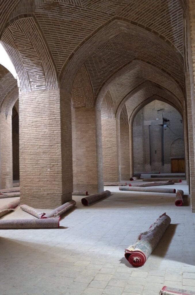 Brick hall with rolled carpets in the Jameh Mosque of Isfahan