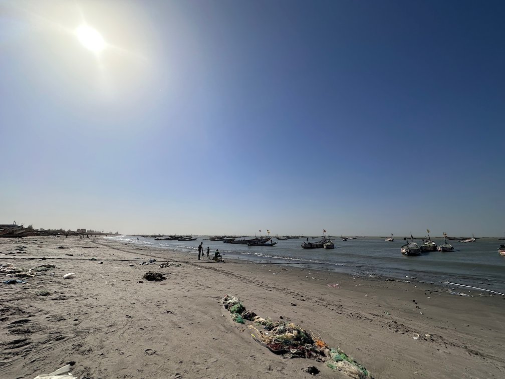 The sun shines over fishing boats near the beach in Joal.