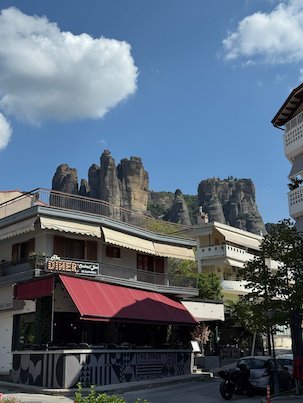 Café building in Kalambaka with the rock towers of Meteora above