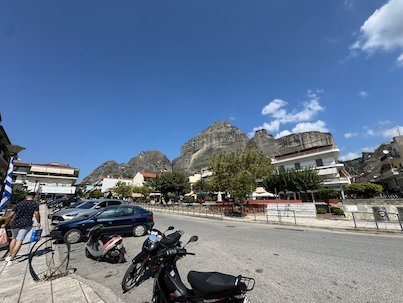 Street in Kalambaka with scooters and the Meteora rocks behind