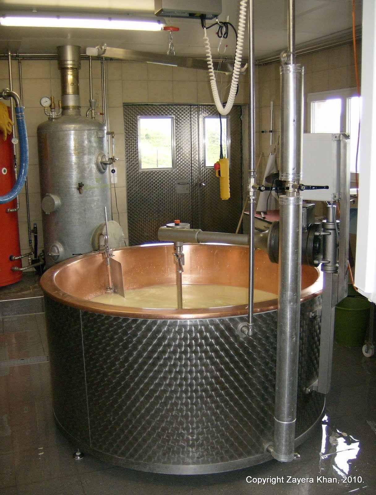 A large copper cheese vat stands in the dairy room of an alp farm in Switzerland.