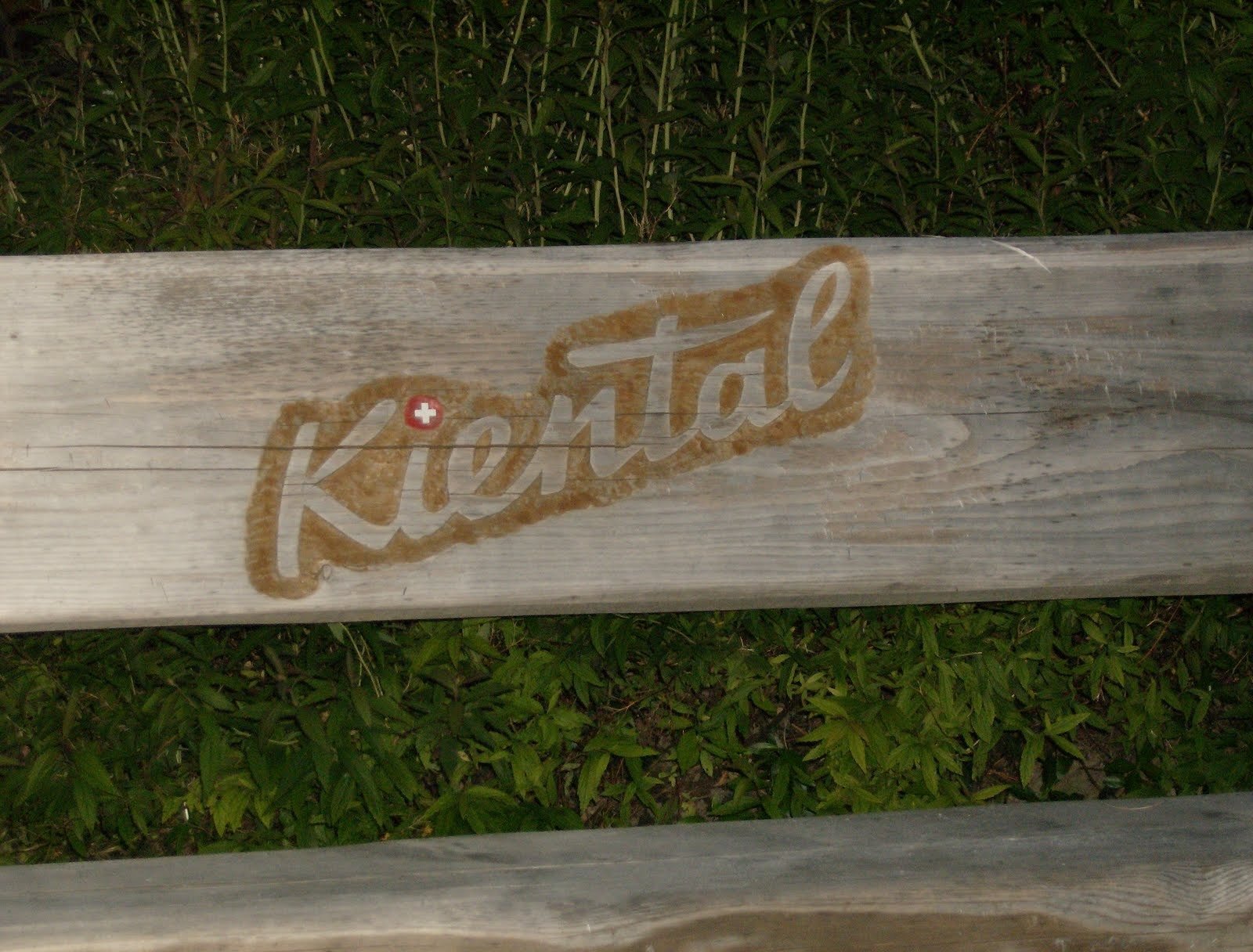 The name Kiental is carved into the wooden back of a bench in Switzerland.