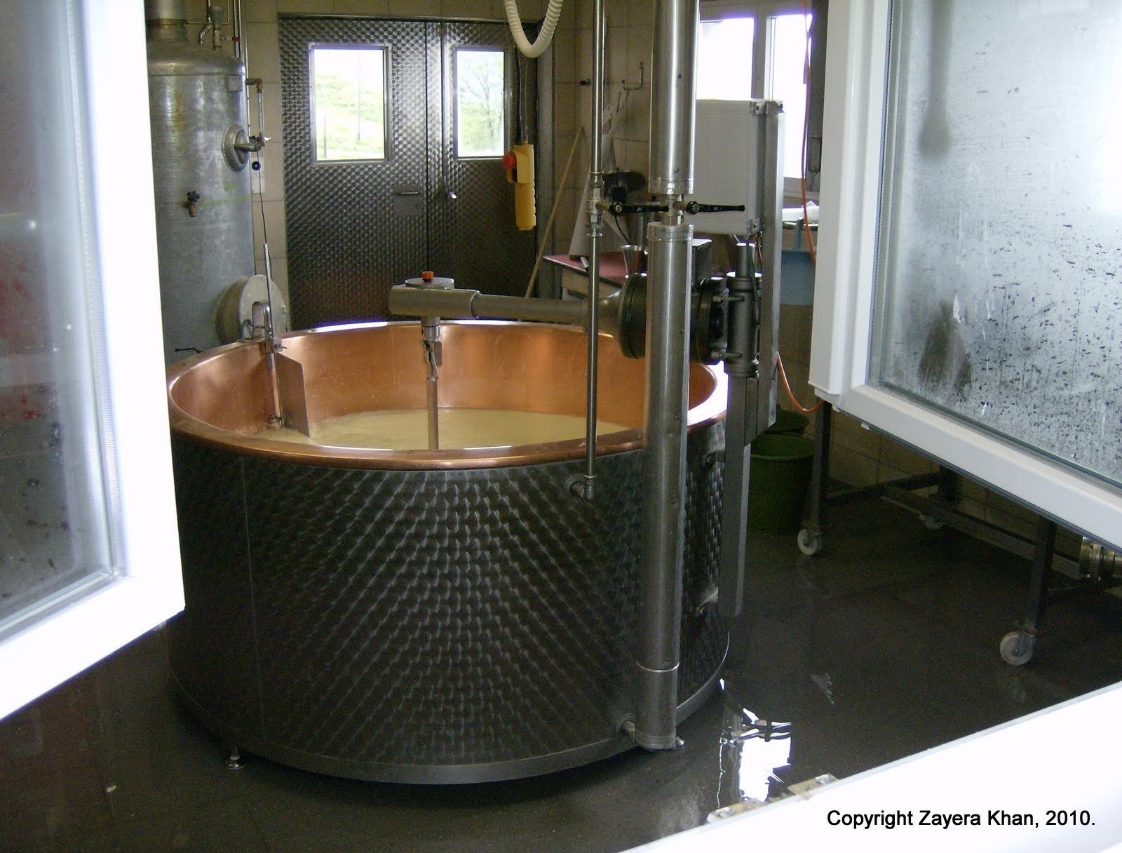 Milk fills a copper cheese vat in the dairy of an alp farm near Kiental.