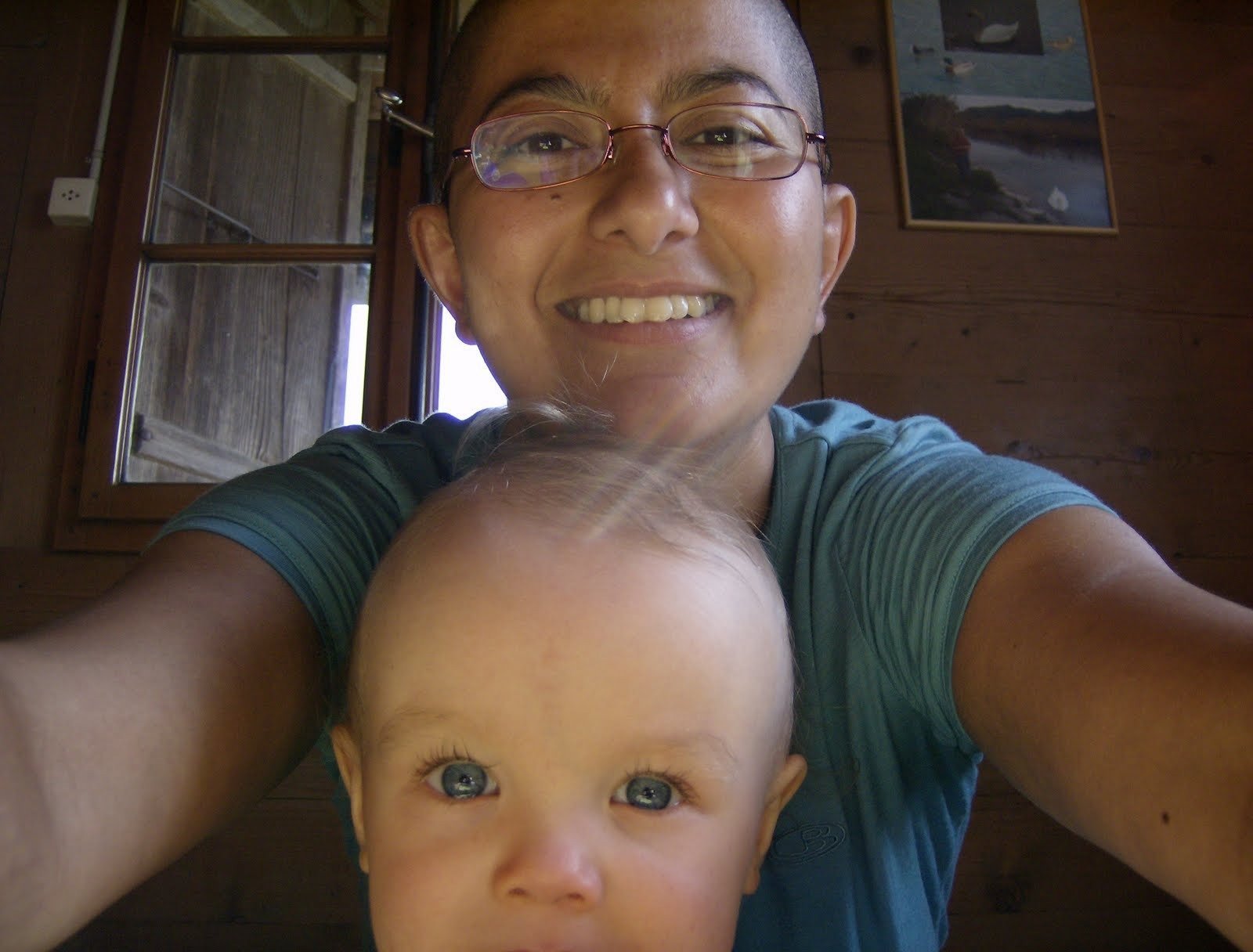 Zayera Khan takes a selfie with a baby inside a wooden alp farmhouse.