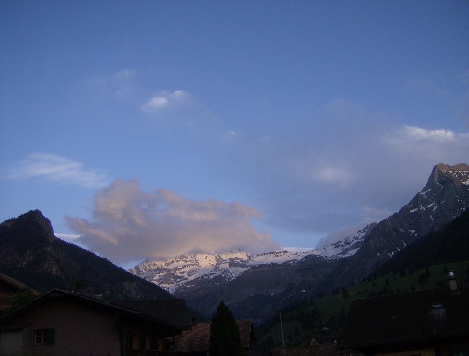 Snowy mountains rise above the Kiental valley under an evening sky.
