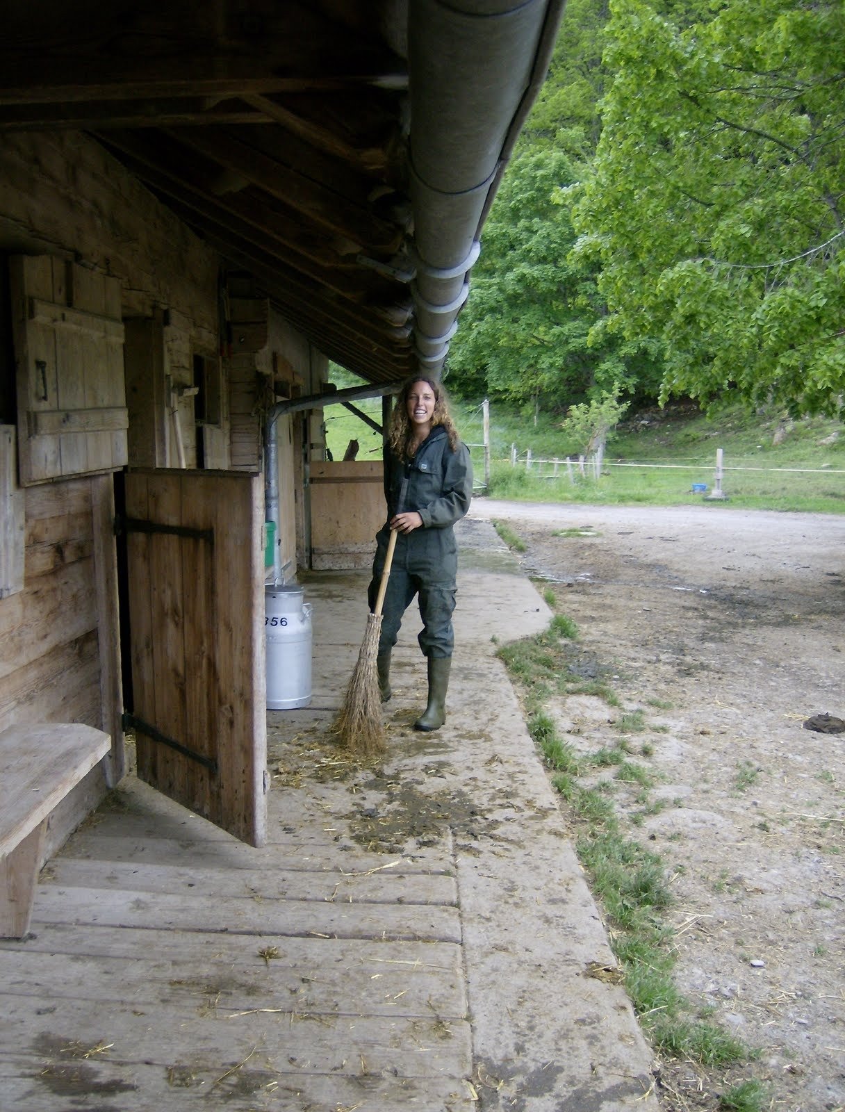 A woman sweeps the path in front of an alp farmhouse in Switzerland.