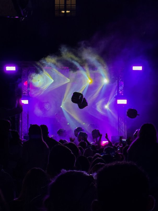 A concert crowd in front of a stage lit in purple light at night during Kulturfestivalen
