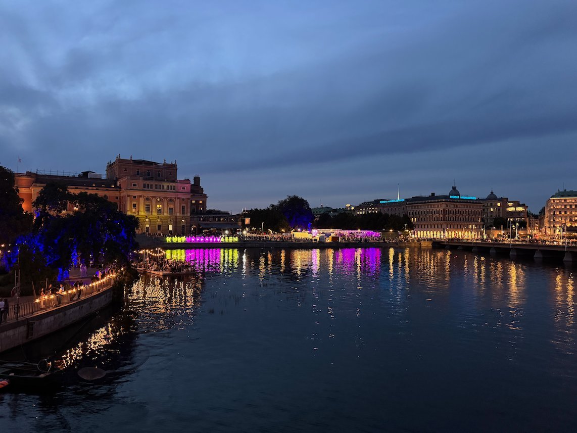 Evening view over Strömmen in Stockholm, with colourful festival lights reflected in the water