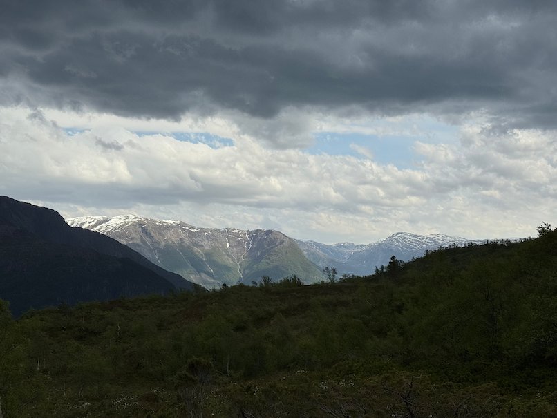 Mountains and fjord under dark clouds