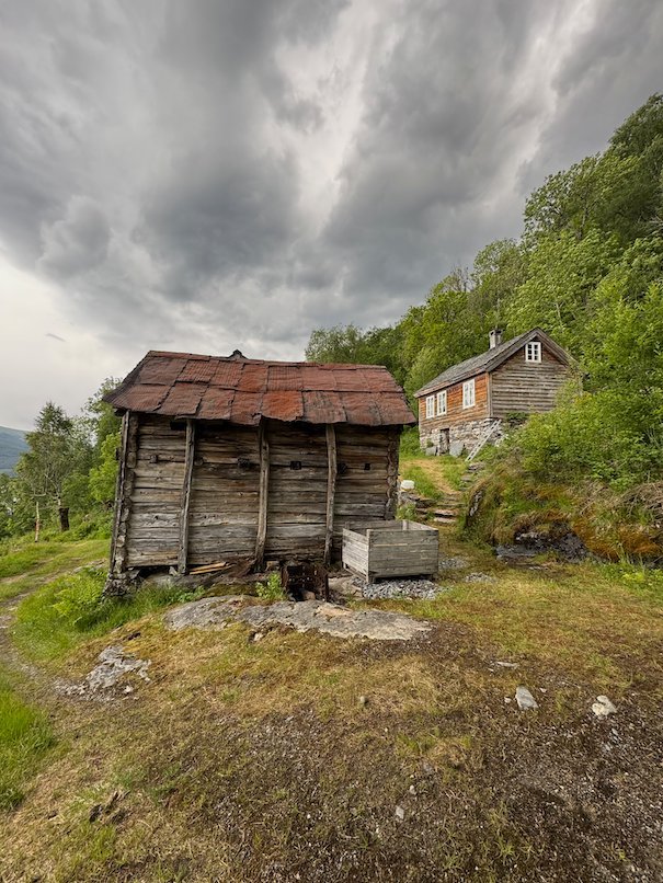 Old log hut and a stone house at the Kvanndalsstølen mountain farm