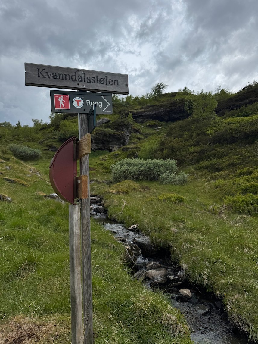 Trail signpost beside a small stream on the Kvanndal trail