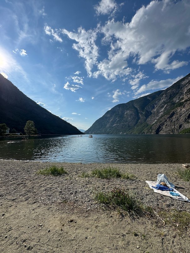 Small beach by the Lærdalsfjord, with steep mountains on both sides