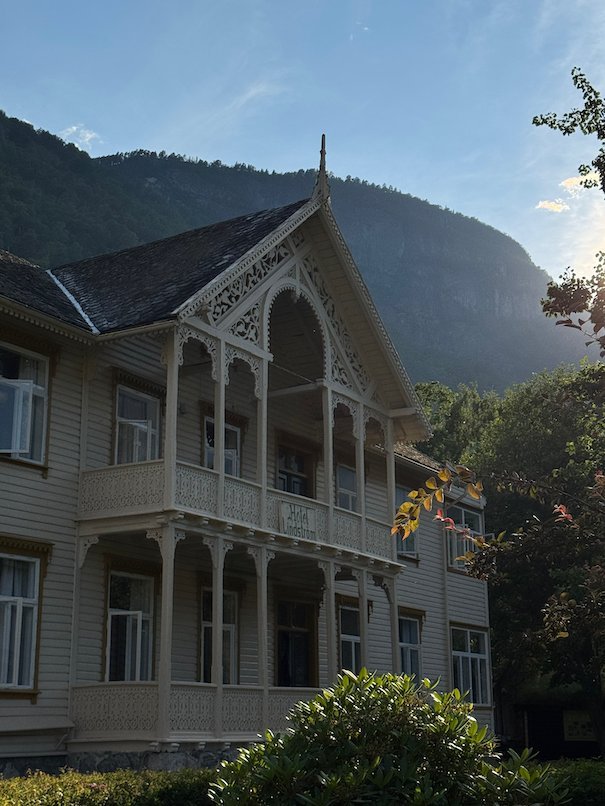 Large white wooden villa with carved balconies in Lærdalsøyri