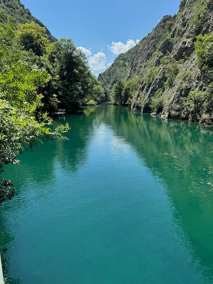 A green river runs between steep wooded cliffs in Matka Canyon near Skopje.