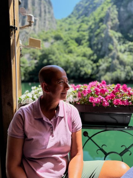 Zayera Khan sits by a window box of pink flowers at a restaurant in Matka Canyon.