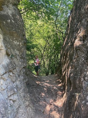 A traveler stands on a trail between two tall rocks at Matka Canyon near Skopje.