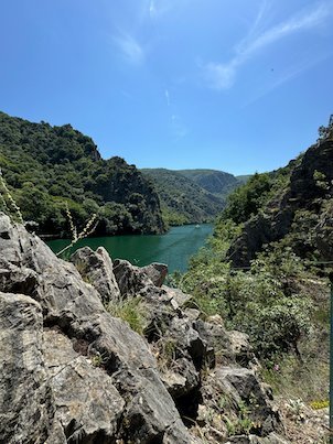Grey rocks frame a view of the lake and hills in Matka Canyon near Skopje.