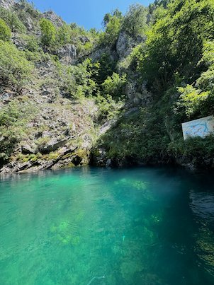 Turquoise water lies below green cliffs in Matka Canyon near Skopje.