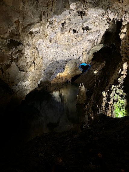 Lights show rock formations and a dark pool inside Vrelo Cave at Matka near Skopje.