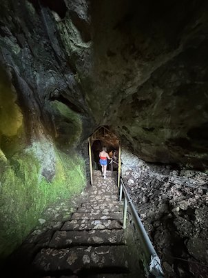 Stone stairs with a railing lead out of the entrance of Vrelo Cave at Matka.