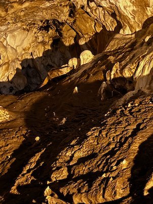 Warm light shows golden rock formations inside Vrelo Cave at Matka near Skopje.