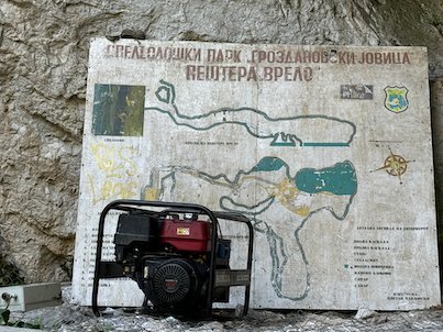 A map of Vrelo Cave is painted on a rock wall behind a generator at Matka.