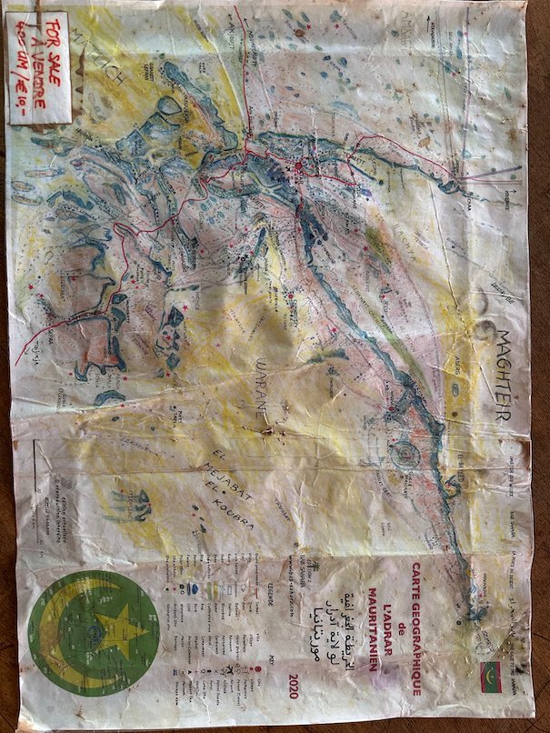 A painted map of Mauritania hangs on a wall.