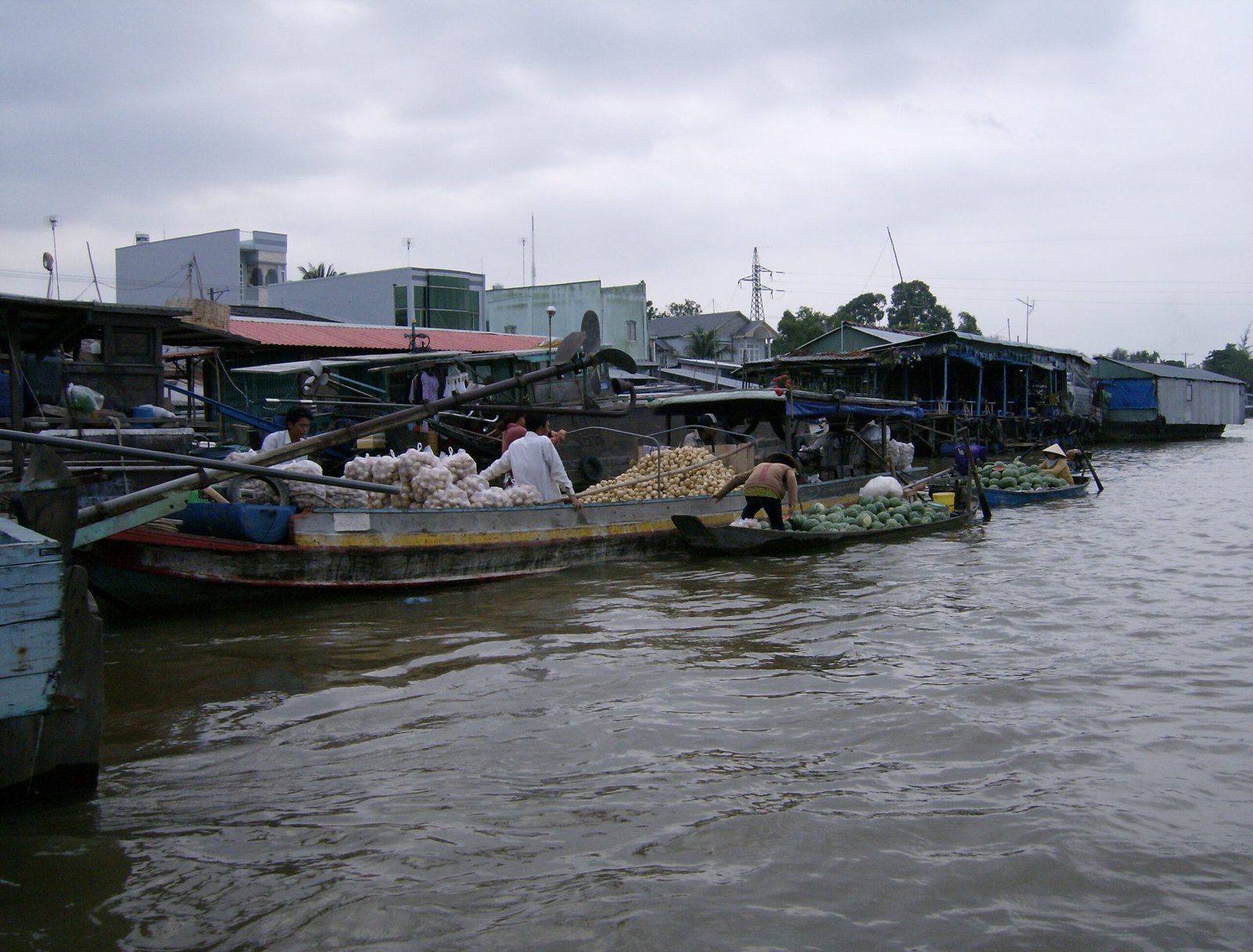 Loaded boats lie side by side at a floating market on a river in the Mekong Delta.
