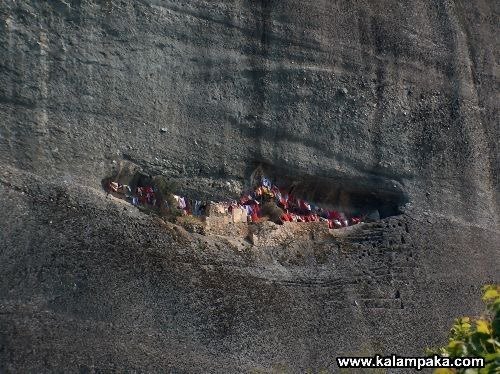 Colored cloths in a cave in the rock face at Meteora