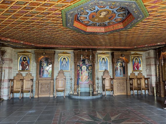 Church interior with an iconostasis, wooden seats and a painted ceiling at Meteora