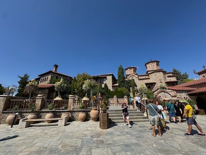 Monastery courtyard with large pots, trees and visitors at Meteora