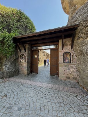 Wooden gate and a stone tunnel at the entrance of a Meteora monastery